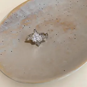 Vista dettagliata di un anello a stella in zircone su un piatto di ceramica strutturato.