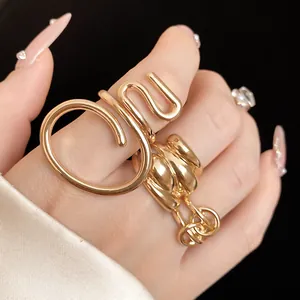 Detailed close-up showing texture of golden oval overlapping hollow rings on a finger