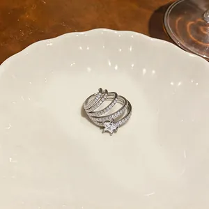 Vista dettagliata del ear cuff a stella in argento con zirconi su piatto di ceramica