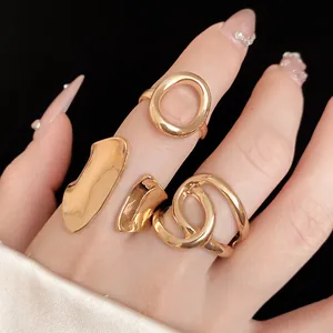 Close-up detail of three elegant gold intertwined and oval hollow rings worn on model fingers