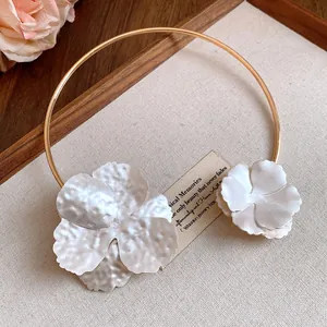 Exquisite macro detail of a gold-tone choker with textured white metal floral accents