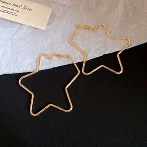 Detailed view of oversized 18k gold plated star-shaped hoop earrings with textured finish