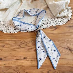 Detailed close-up of a resort style floral fabric scarf necklace with a golden ring