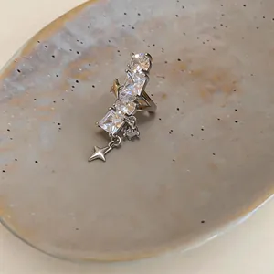 Vista dettagliata di un ear cuff a stella in argento con zirconi lucidi su un vassoio