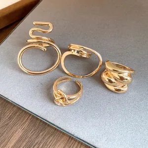 Detailed view of minimalist gold-plated geometric rings with twisted hollow designs