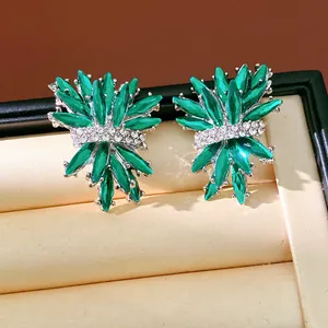 Primer plano de pendientes irregulares en forma de fuegos artificiales con cristales verdes