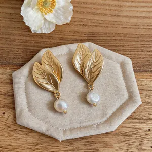 Detalle de pendientes de hoja dorada con perlas naturales de agua dulce