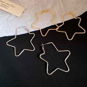 Detailed macro view of large star-shaped hoop earrings in gold and silver finishes