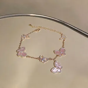 Elegantes goldenes Schmetterlingsarmband mit funkelnden rosa Flügeln und Zirkonia