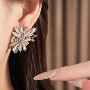 Primer plano de pendientes de diamantes de imitación con forma de fuegos artificiales