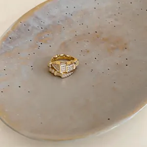 Vista macro dettagliata di un earcuff dorato di lusso con intarsi di zirconi