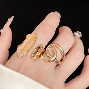 Close-up of gold chunky rings featuring irregular oval and hollow intertwined designs