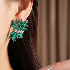 Primer plano de elegantes pendientes de cristal verde con forma de fuegos artificiales