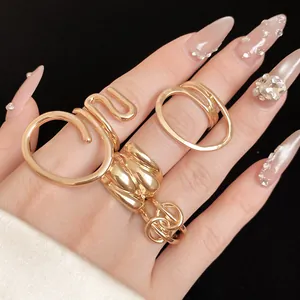 Detailed view of elegant gold-toned rings with unique oval and twisted hollow designs