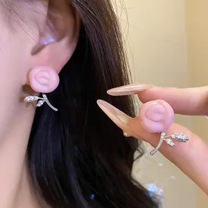 Detail view of pink resin rose earrings with sparkling zircon-encrusted leaf drops.