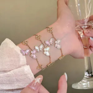 Detailaufnahme von eleganten Gold-Schmetterlingsarmbändern mit pinkem und weißem Zirkonia