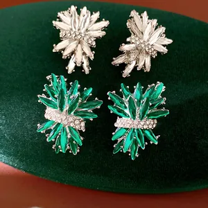 Primer plano de pendientes de strass con forma de fuegos artificiales, verde y blanco.