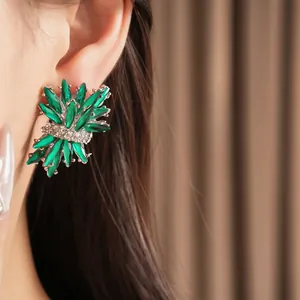 Detalle de pendientes de fuegos artificiales de cristal verde con brillantes diamantes.