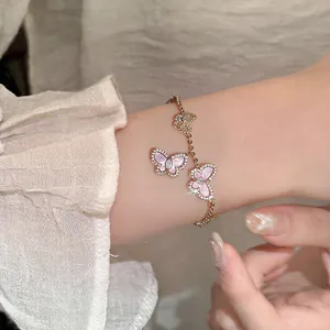 Detailansicht eines funkelnden Zirkon-Schmetterlingsarmbands mit rosa Steinen am Handgelenk