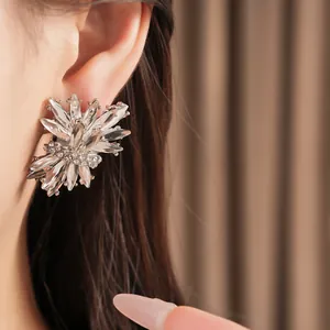 Detalle de pendientes de botón con forma de fuegos artificiales plateados para mujer