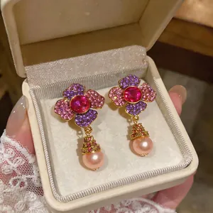Luxury flower stud earrings featuring pink crystals and elegant pearl drops in a gift box