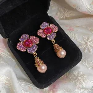Elegant floral pearl drop earrings with pink and purple crystal stones in a jewelry box