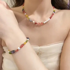 Detail view of colorful beaded necklace and matching bracelet set worn by a model