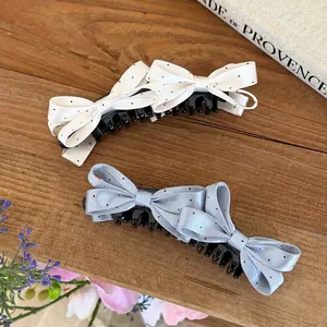 Vista dettagliata di eleganti fermagli per capelli con fiocco a pois su legno rustico