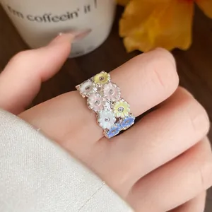 Macro view of a sweet floral ring with multi-colored resin flowers and sparkling zircons