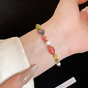 Detailed close-up of a colorful natural stone and pearl beaded bracelet on a wrist