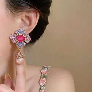 Detailed view of elegant vintage floral crystal drop earrings with pink pearl on model