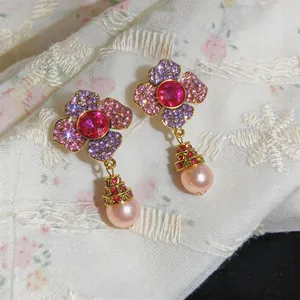 Close-up detail of vintage floral earrings with colorful rhinestones and pink pearls