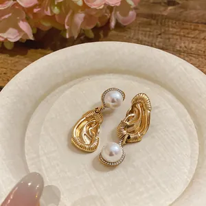Primo piano di orecchini vintage a forma di orecchio con grandi perle e diamanti