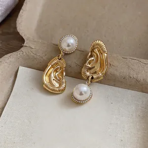Vista dettagliata di orecchini vintage in oro con perle e cristalli incastonati