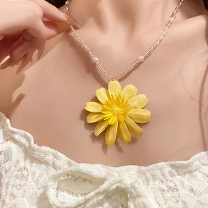 Gros plan détaillé d'un collier de perles marguerite jaune sur le cou d'un modèle de mode
