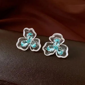 Elegant transparent flower stud earrings with light blue zircons for a luxury fashion look.