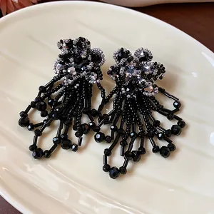 Κομψά σκουλαρίκια με μαύρα γυάλινα λουλούδια και ασημί λεπτομέρειες.
