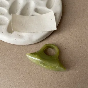 Close-up of minimalist green marble pattern resin ring on neutral textured background