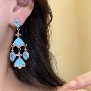 Gros plan sur des boucles d'oreilles vintage style palais avec acétate bleu et zircons