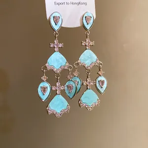 Vue détaillée de boucles d'oreilles style palais vintage en acétate bleu et zircons roses.