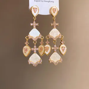Vue détaillée de boucles d'oreilles style vintage avec zircon rose et franges