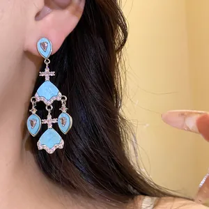 Gros plan détaillé de boucles d'oreilles vintage avec acétate bleu et zircons roses