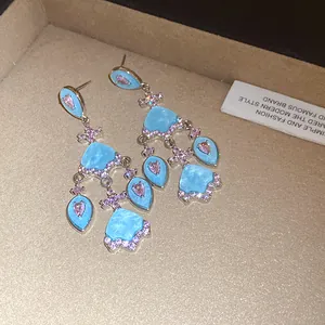Vue détaillée de boucles d'oreilles vintage avec zircon bleu ciel et rose brillant