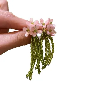 Fresh pink flower stud earrings with long green beaded tassels for a chic spring look