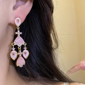Gros plan de boucles d'oreilles vintage en acétate rose avec des éclats de zircon