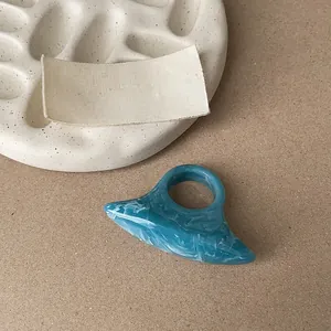 Close-up of a blue resin ring with unique marble texture and geometric design.