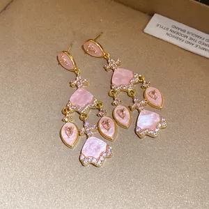 Gros plan de boucles d'oreilles vintage en acétate rose avec détails en zircon