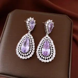 Detailed view of teardrop earrings with lavender crystals and silver plating