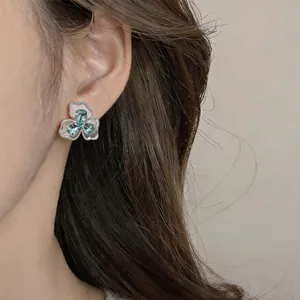 Detailed view of elegant silver needle flower stud earrings with blue zircons