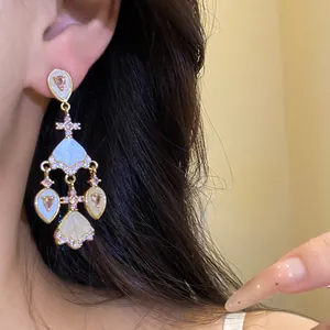 Gros plan de boucles d'oreilles pendantes vintage avec zircons roses sur un mannequin asiatique